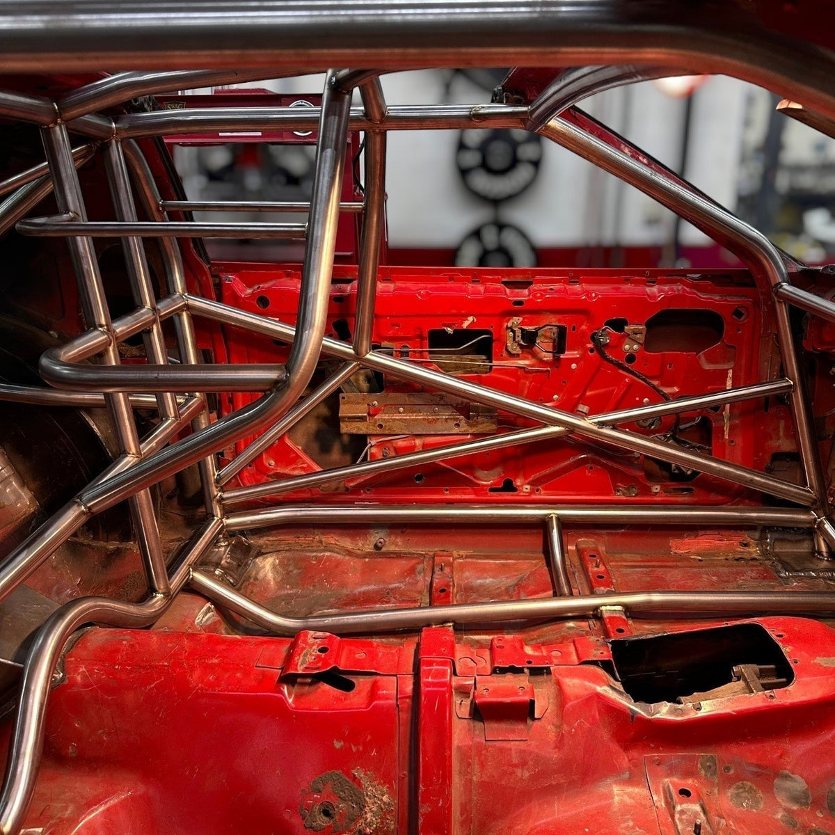 Henderson Race Shop 25.5 roll cage kit installed in a red 1982-1992 Camaro or Firebird interior with T-tops.