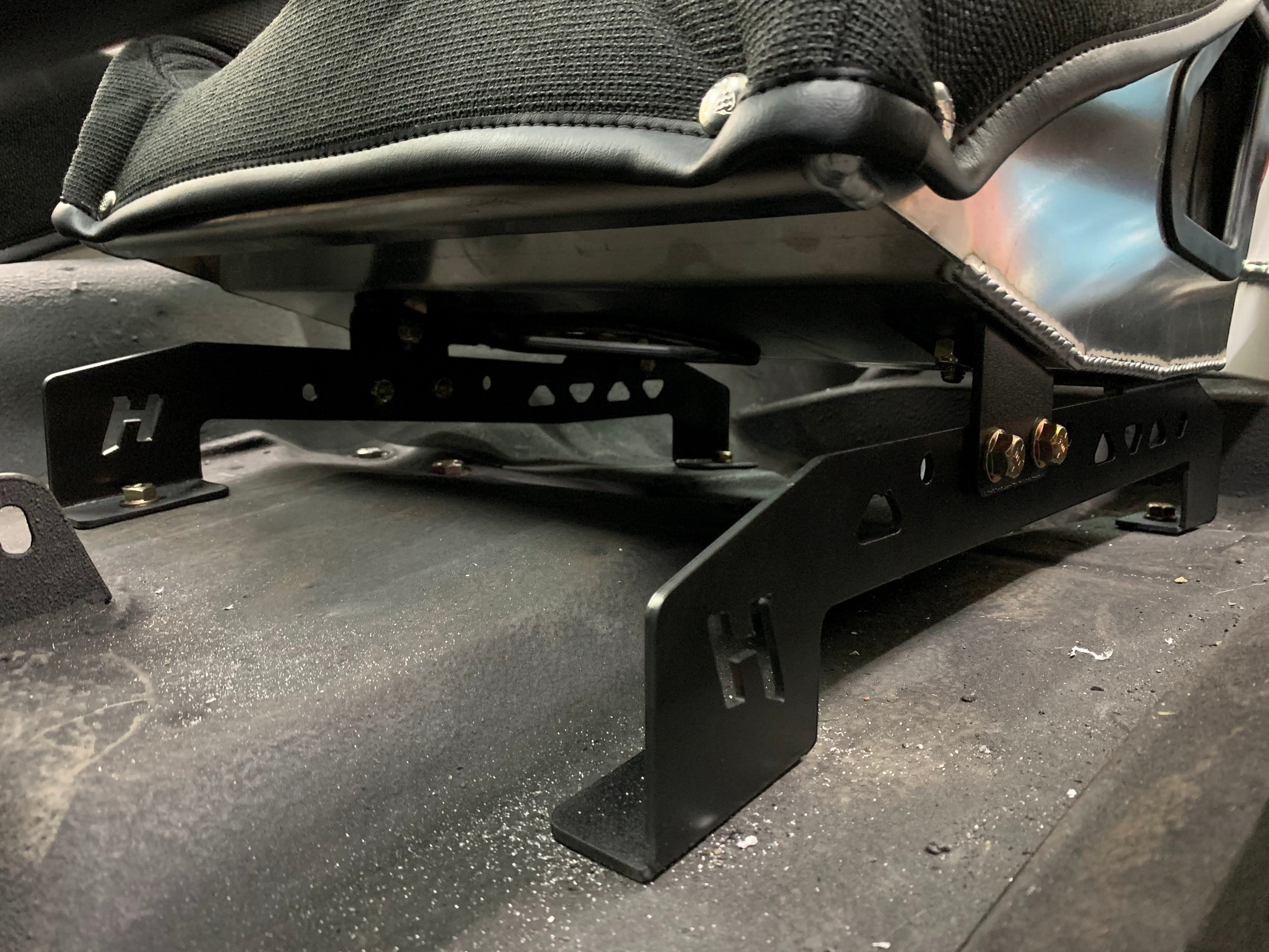 Henderson Race Shop black powder-coated steel seat mounts installed under a Kirkey racing seat in a 2nd Gen Camaro