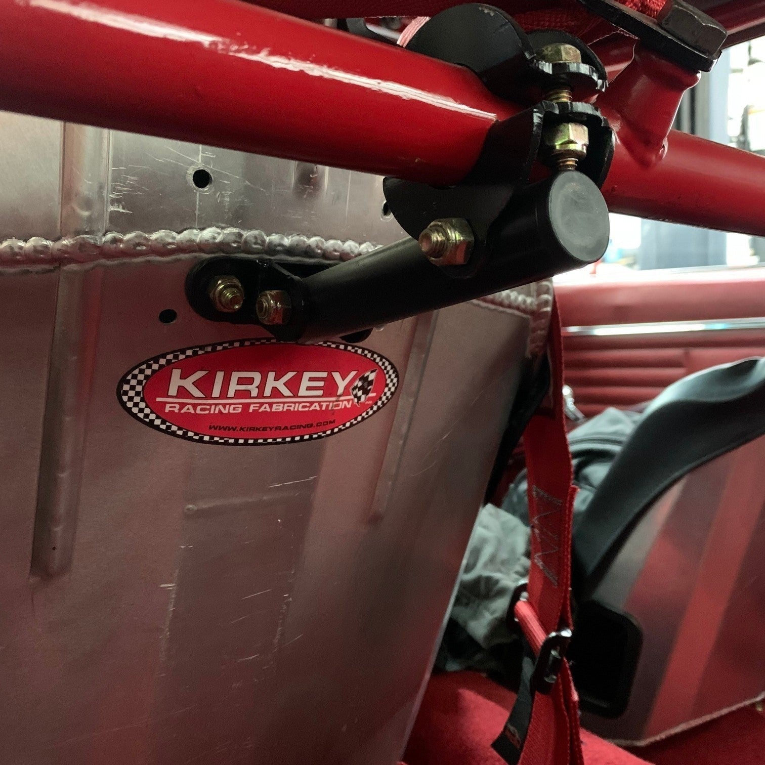 Henderson Race Shop Store bolt-on seat back brace installed on a racing seat with a black powder-coated finish.