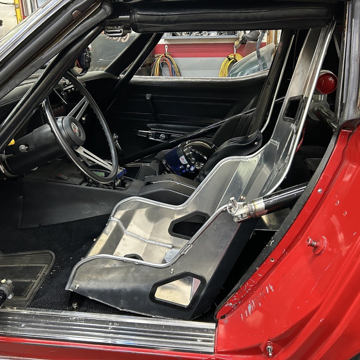 Henderson Race Shop Store seat mounts installed with a Kirkey racing seat inside a red C3 Chevrolet Corvette interior
