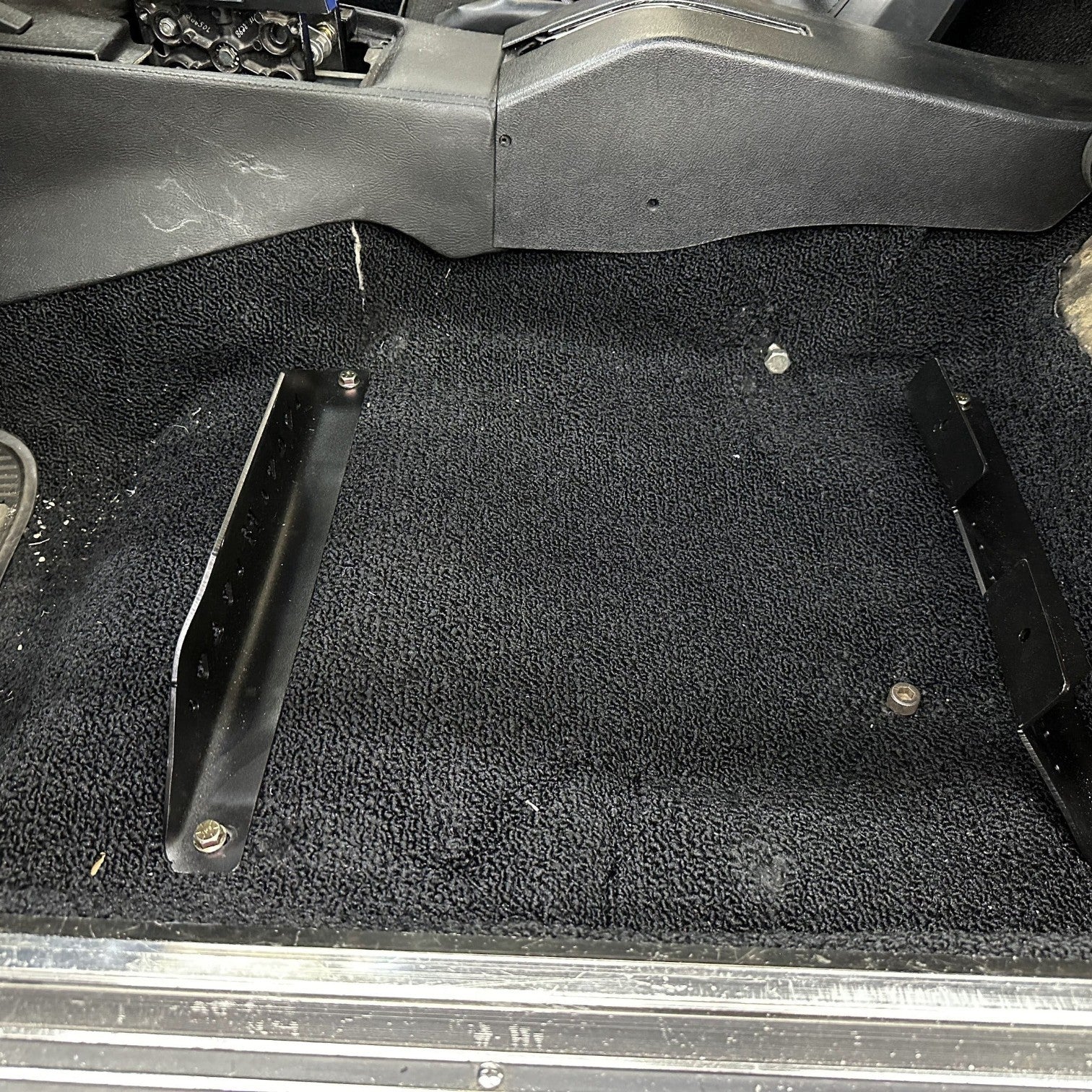 Henderson Race Shop Store black powder-coated steel seat mount brackets installed on the floor of a C3 Corvette.