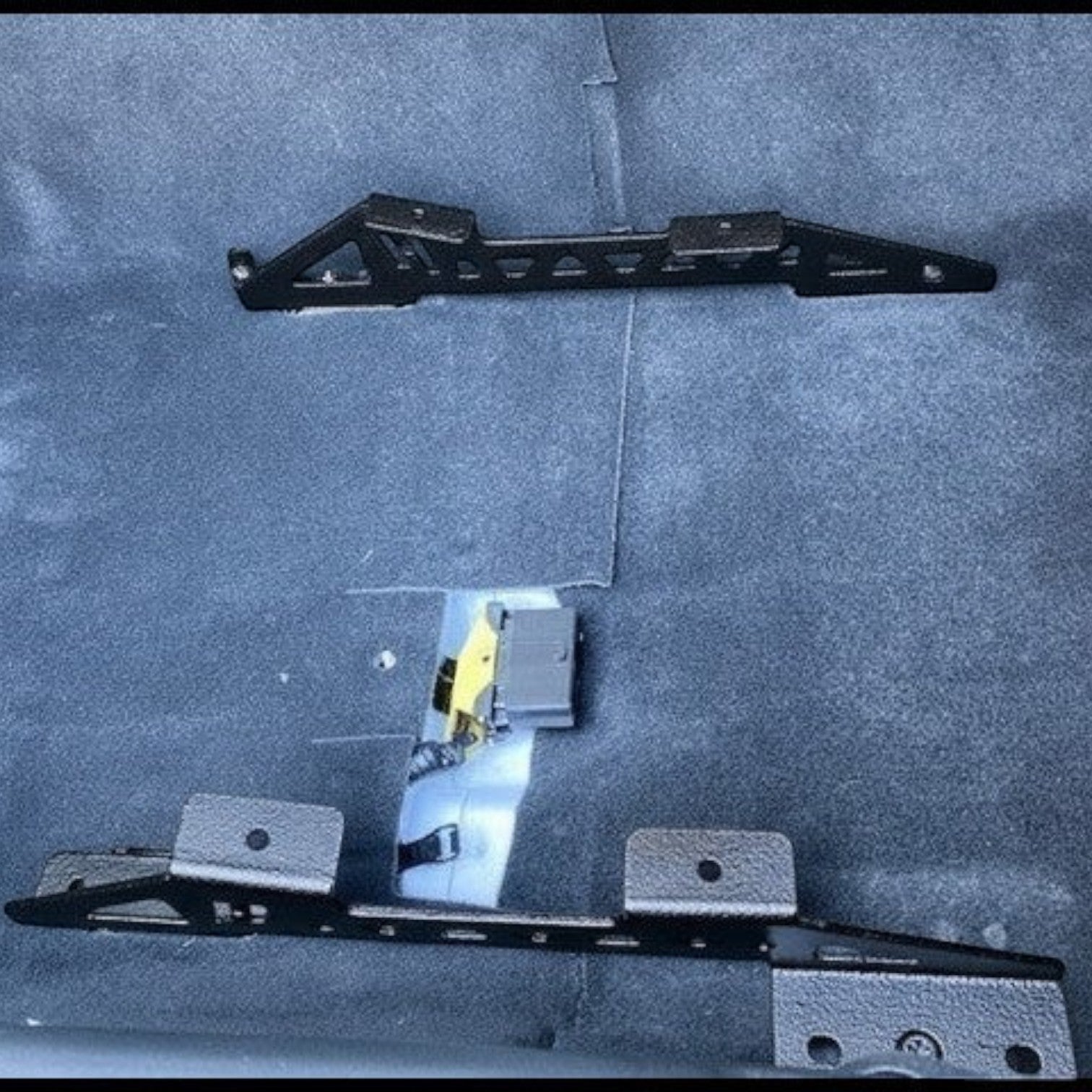 Henderson Race Shop Store black powder-coated steel seat mount brackets installed on the floor of a 6th gen Camaro.