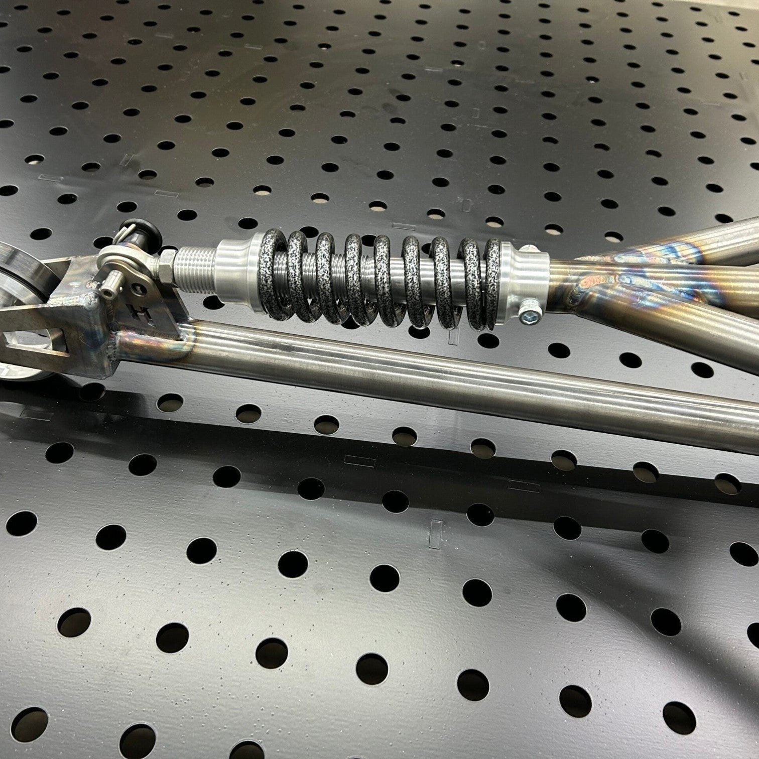 Henderson Race Shop Store chromoly single wheelie bar featuring a heavy-duty spring slider assembly on a pegboard.