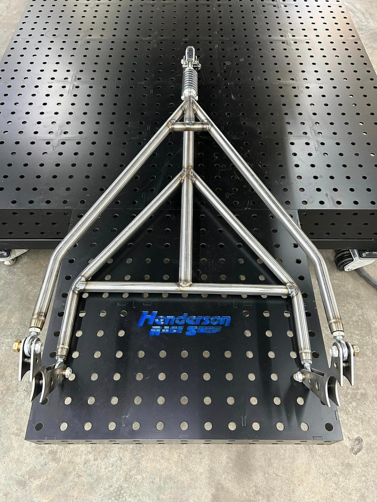 Henderson Race Shop Store chromoly single wheelie bar with heavy-duty spring slider assembly on a welding table.