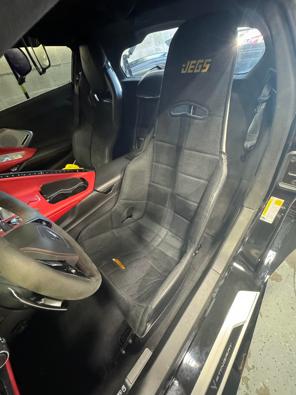 Henderson Race Shop Store seat mounts installed with a black Kirkey racing seat inside a Chevrolet Corvette interior
