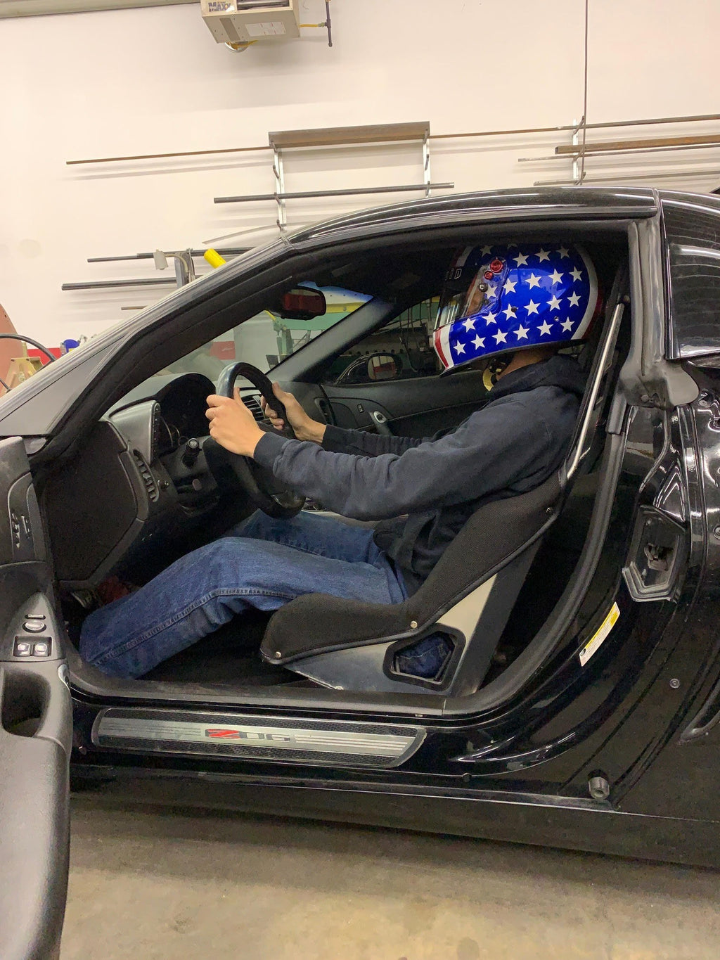 Henderson Race Shop Store seat mounts installed in a Corvette with a driver wearing a star-patterned racing helmet