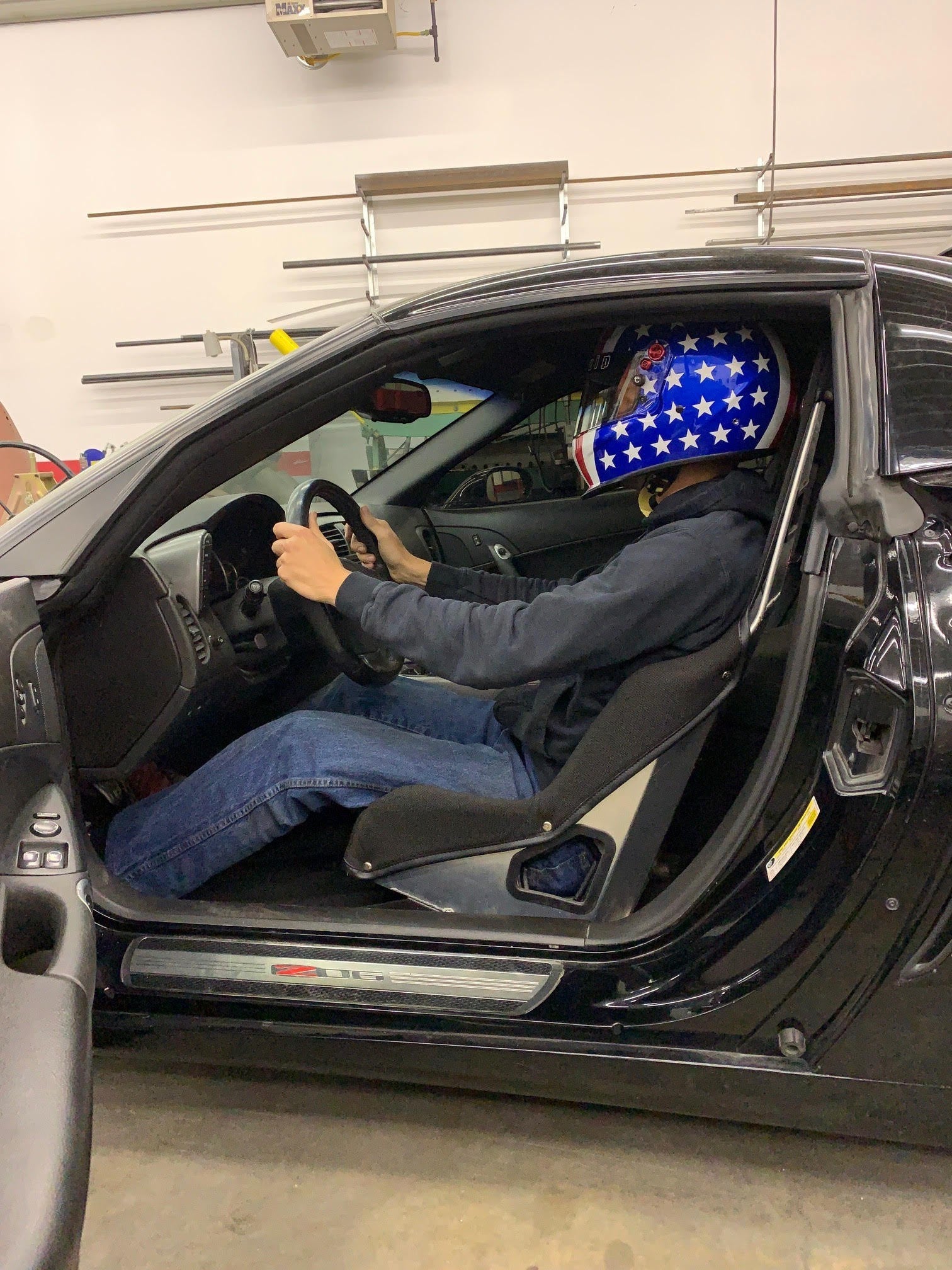 Henderson Race Shop Store seat mounts installed in a Corvette with a driver wearing a star-patterned racing helmet