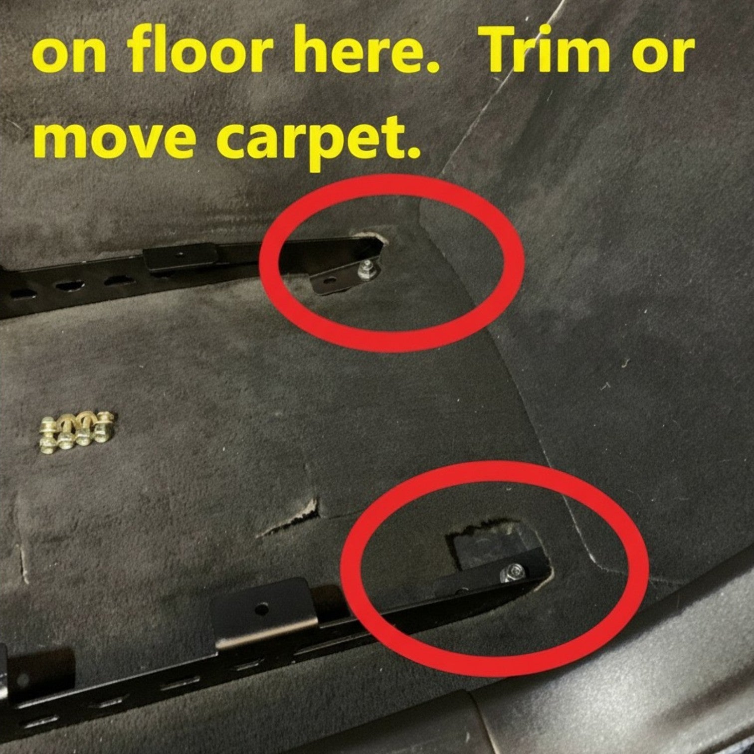 Henderson Race Shop Store black steel seat mount brackets installed on the floor of a Chevrolet Corvette