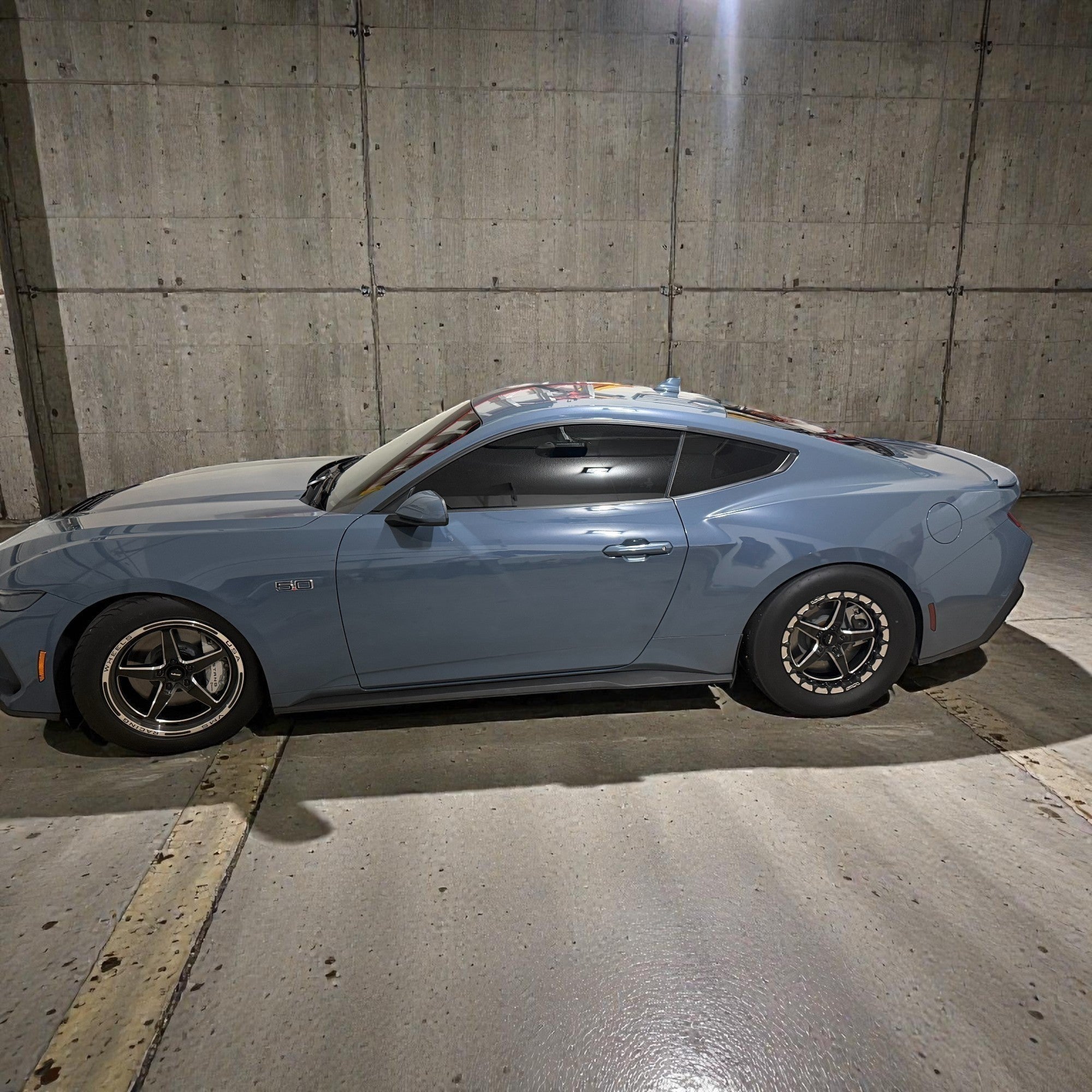 Henderson Race Shop Store grey Ford Mustang S550 parked in a concrete parking garage, side profile view.