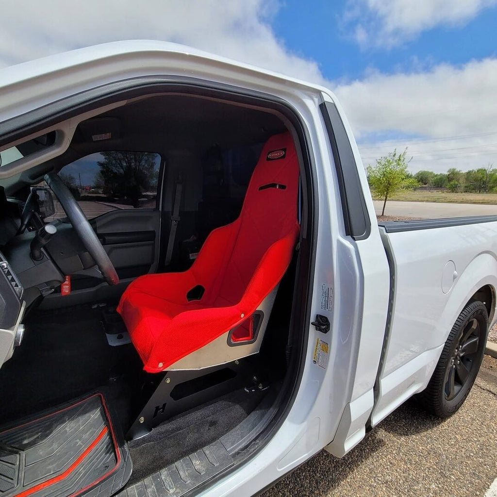 Henderson Race Shop Store seat mounts installed with a red Kirkey racing seat inside a white Ford F-150 truck.