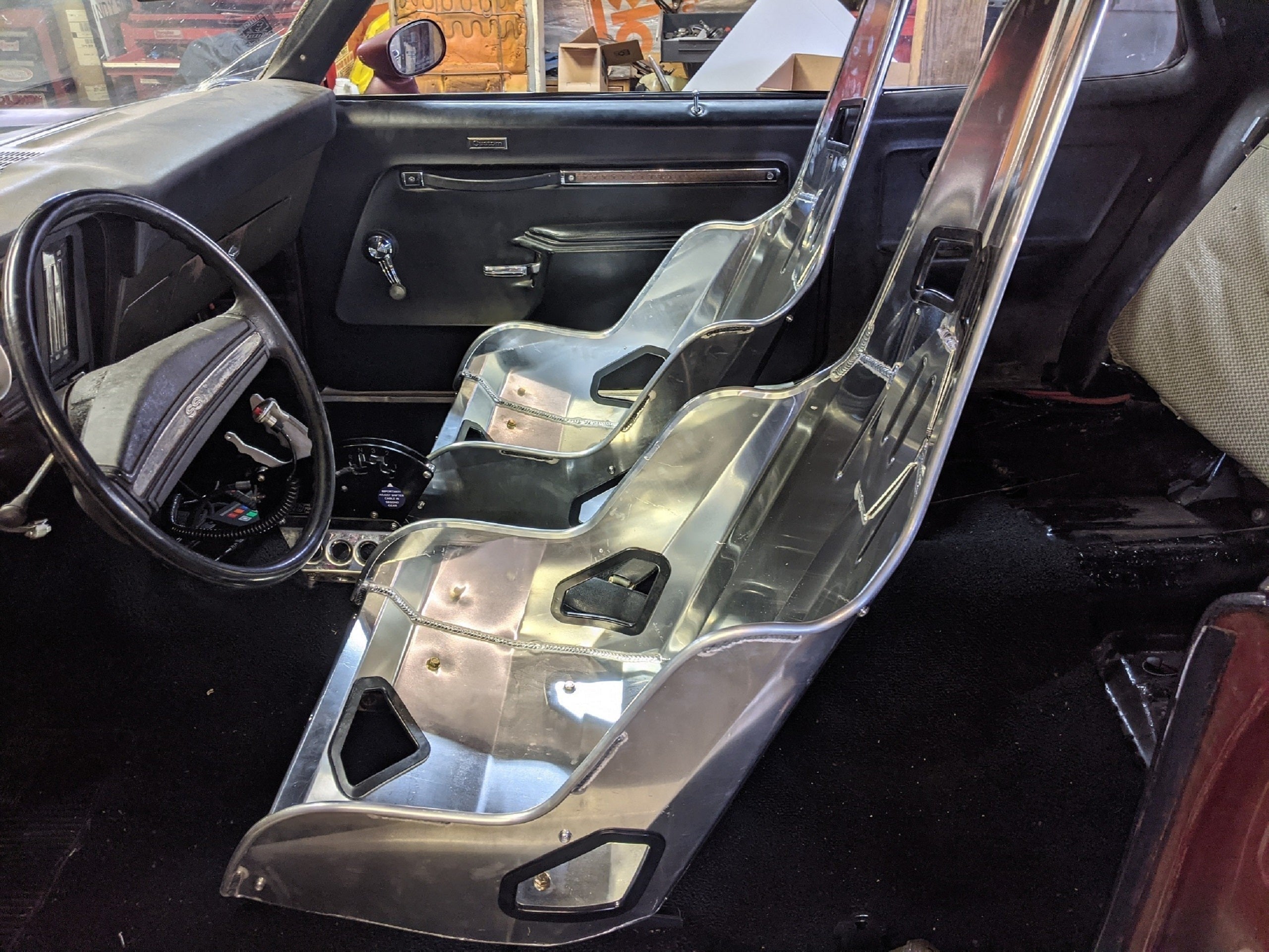 Henderson Race Shop Store seat mounts installed under Kirkey aluminum racing seats in a classic Chevy Nova interior.