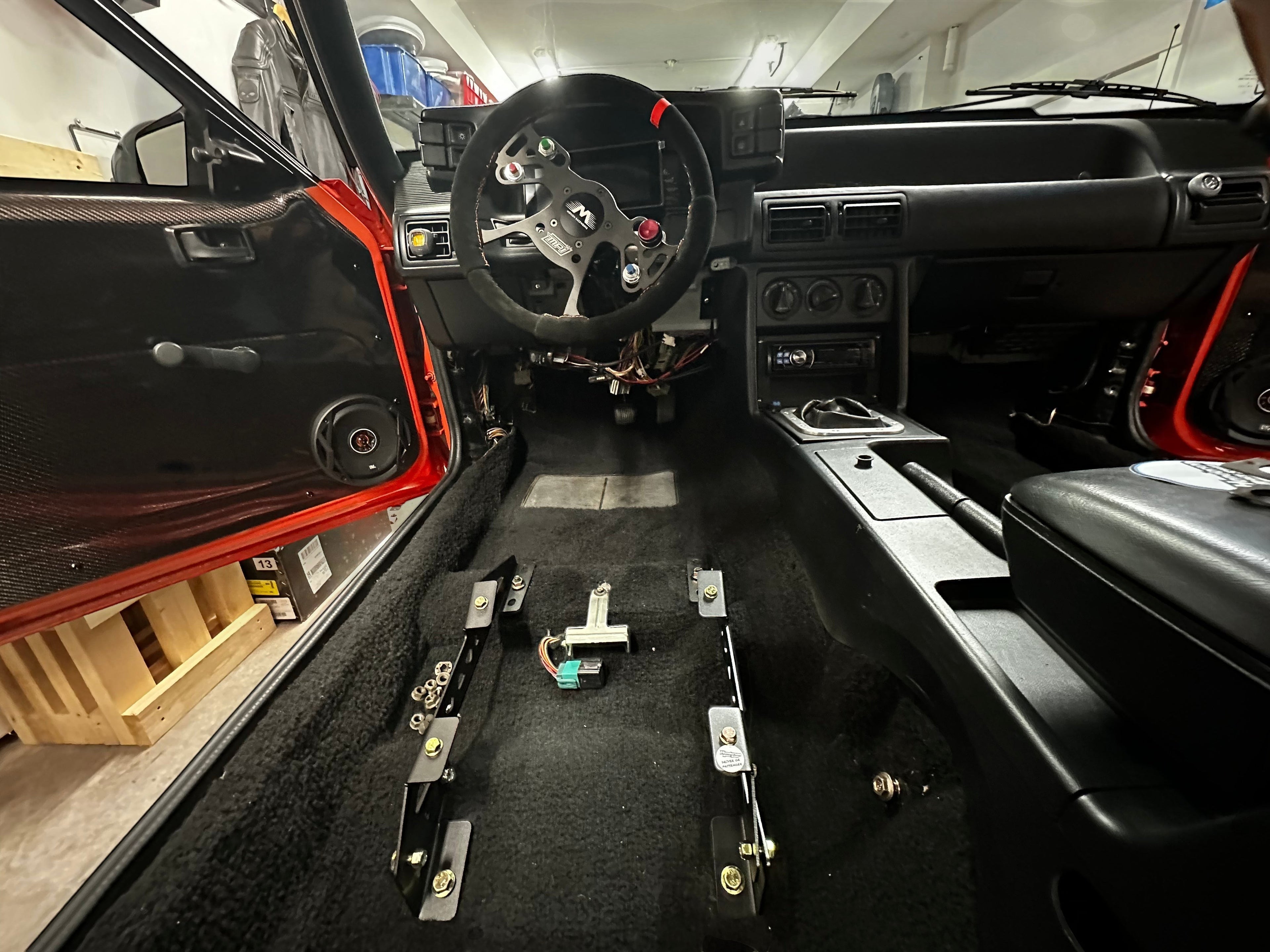 Henderson Race Shop Store black steel seat mount brackets installed on the floor of a Ford Mustang interior