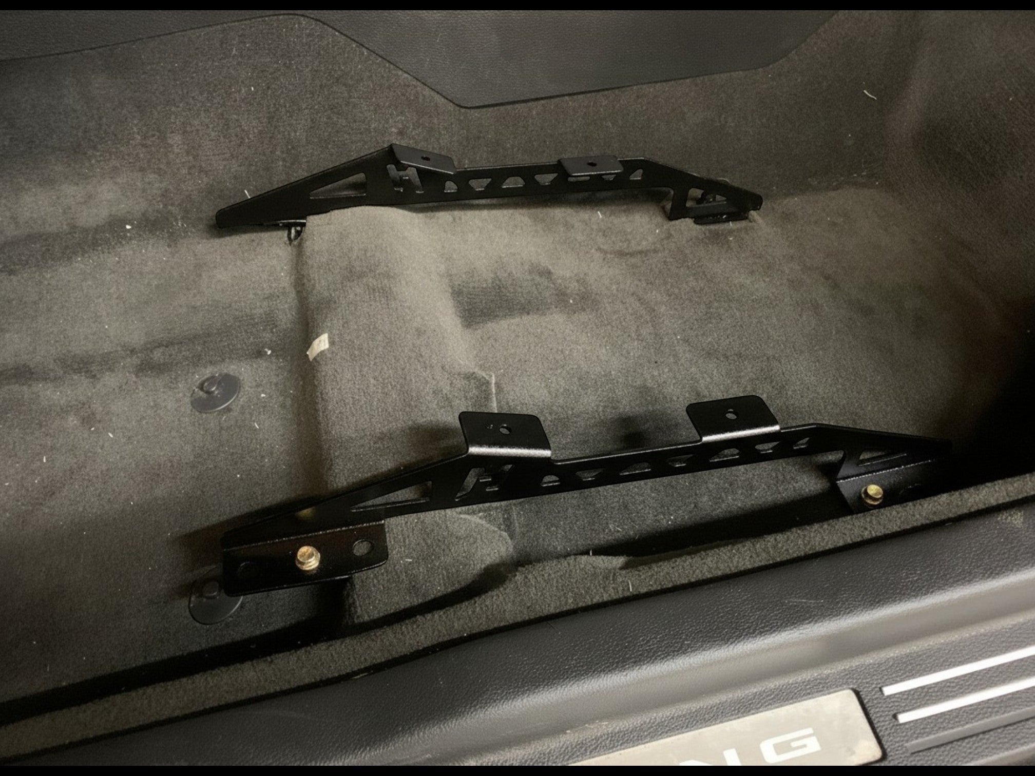 Henderson Race Shop Store black steel seat mount brackets installed on the floor of a Ford Mustang S197