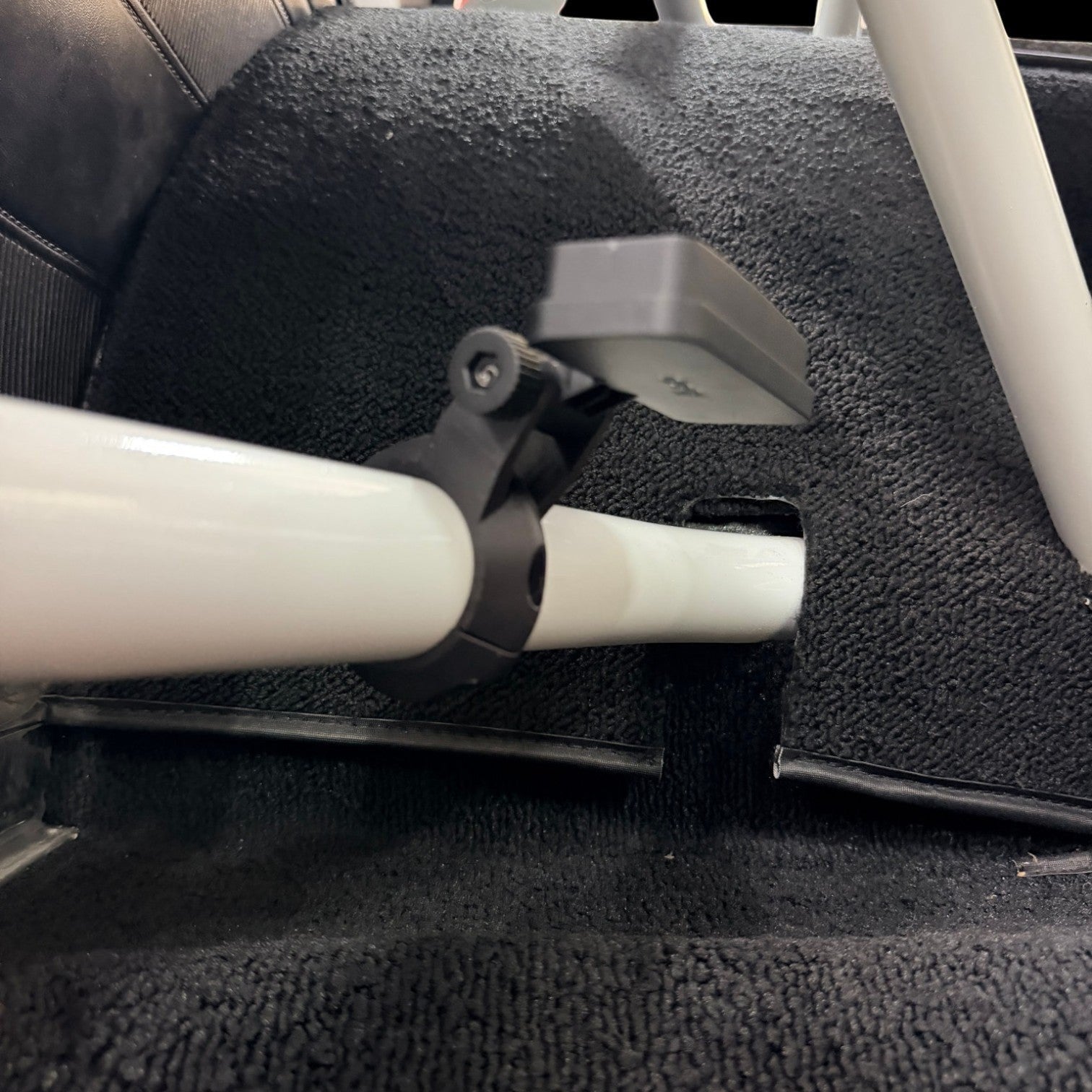 Henderson Race Shop Store 3D printed black roll cage clamp with a mounted dragy device on a white roll bar