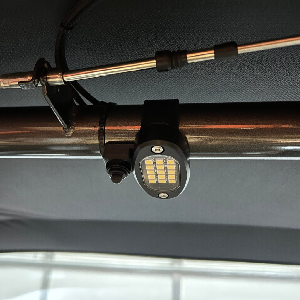 Henderson Race Shop Store LED light switch mounted on a roll cage bar next to an oval LED light fixture