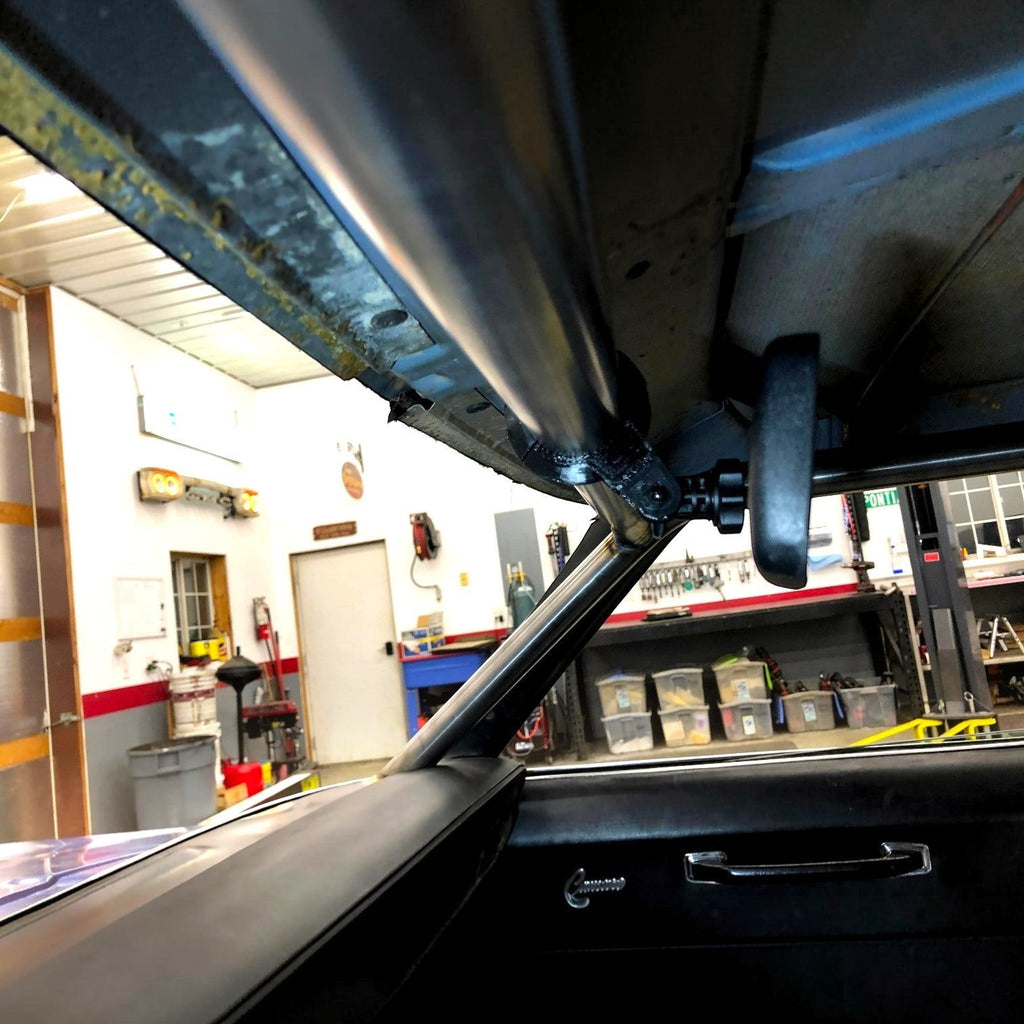 Henderson Race Shop Store lightweight rear view mirror mounted on a black roll cage tube inside a race car garage