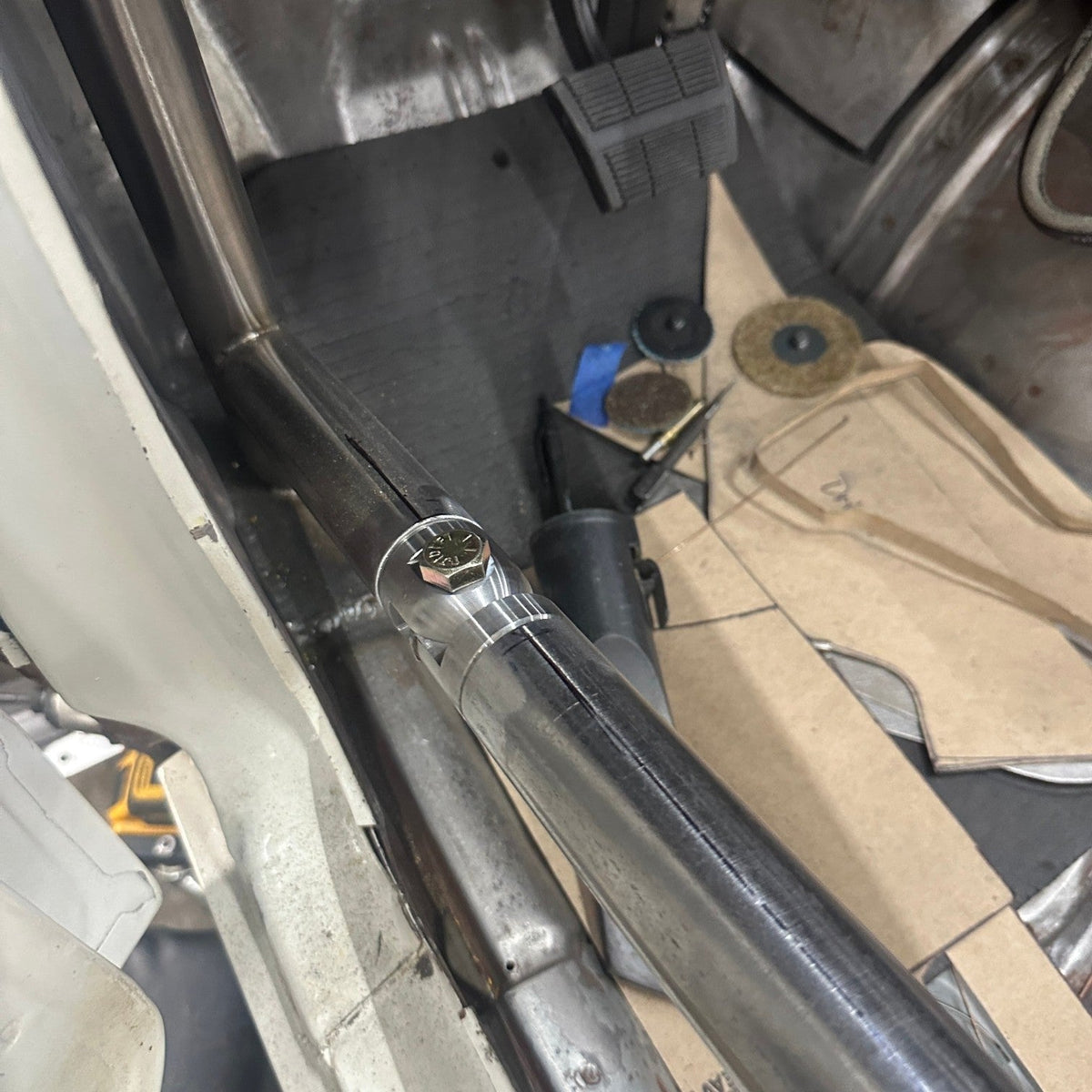 Henderson Race Shop Store roll cage swing-out kit installed on a race car door bar with a precision-machined steel joint