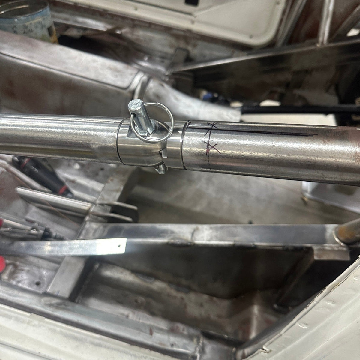 Henderson Race Shop Store roll cage swing out kit installed on steel tubing with a quick release pin in a race car