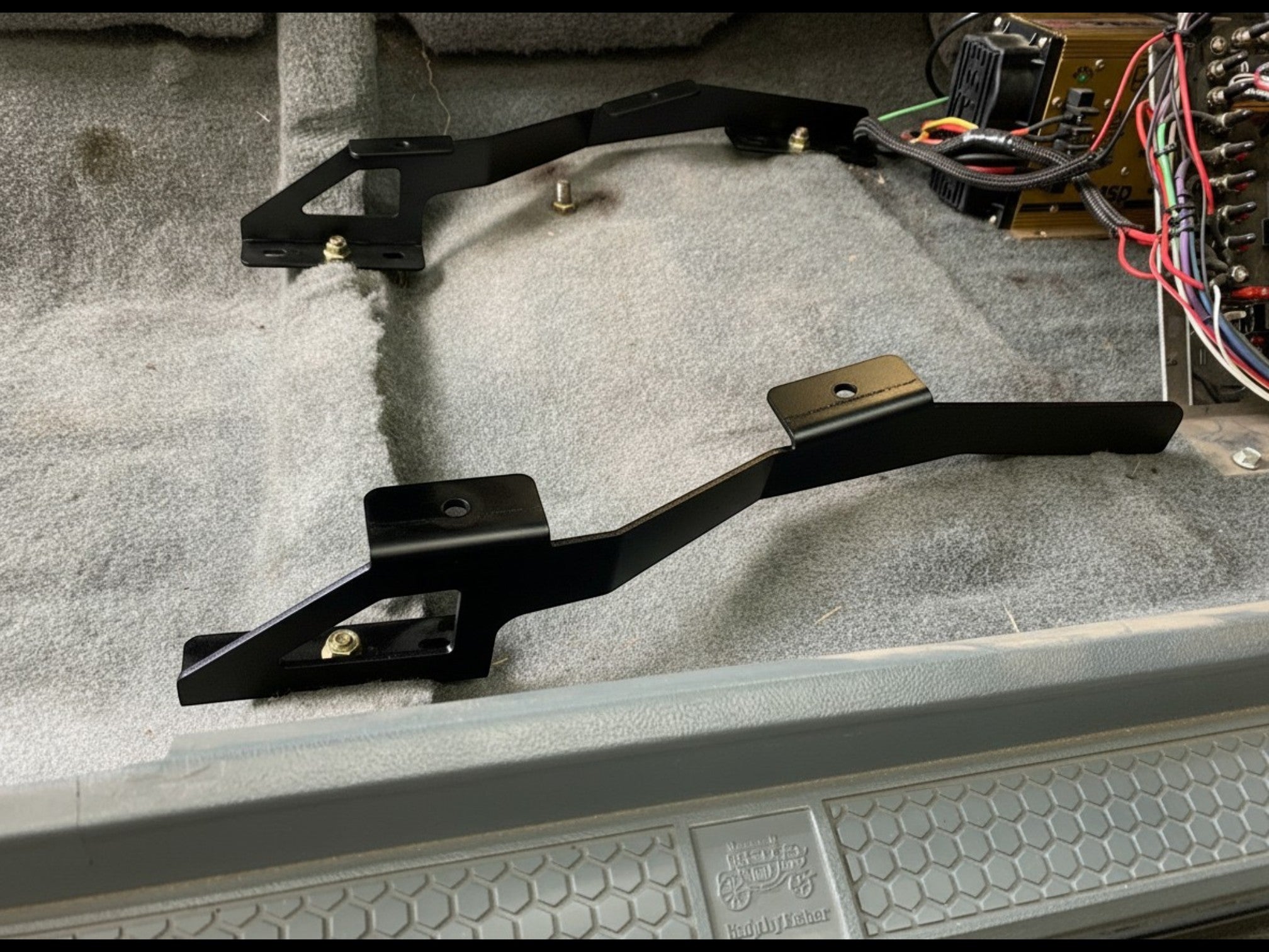 Henderson Race Shop Store black steel seat mount brackets installed on a Camaro or Firebird floor pan