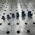 Henderson Race Shop Store black single flat base AN hose clamps in various sizes arranged on a metal welding table.