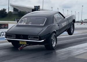 Henderson Race Shop Store single wheelie bar installed on a black drag racing car performing a wheelie on the track