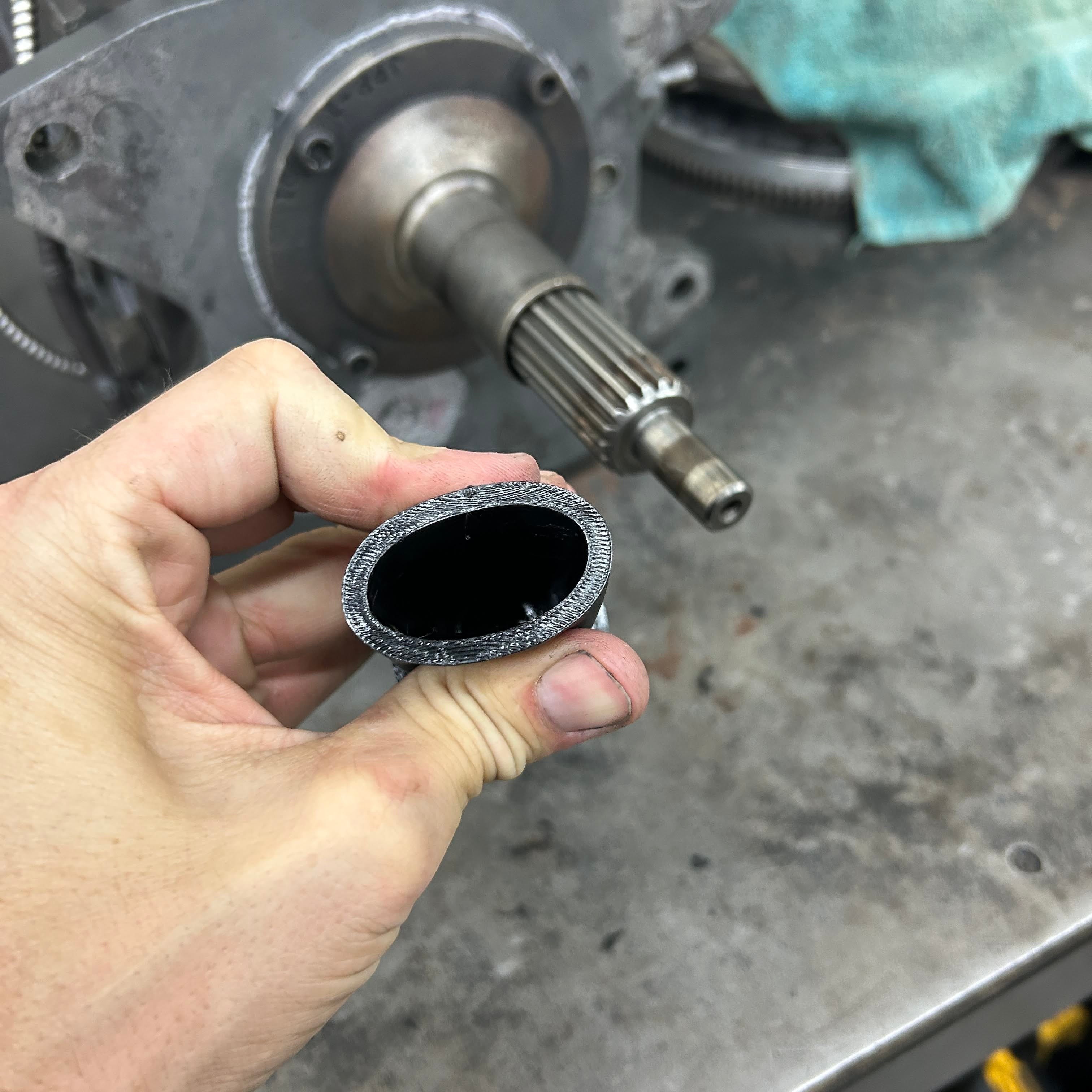 Henderson Race Shop Store transmission input shaft alignment tool held in hand during a transmission rebuild