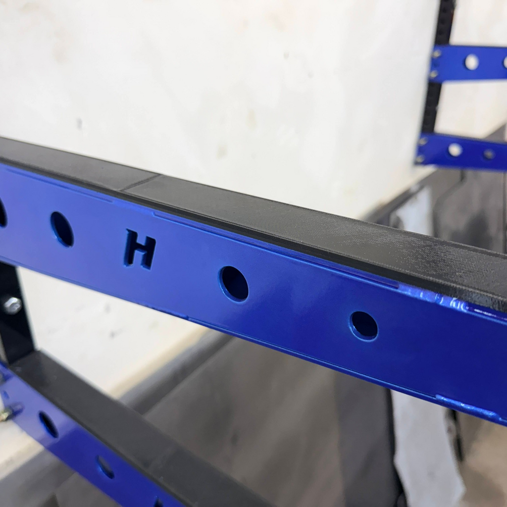 Henderson Race Shop Store wall mounted metal storage rack with blue steel arms and protective black TPU covers