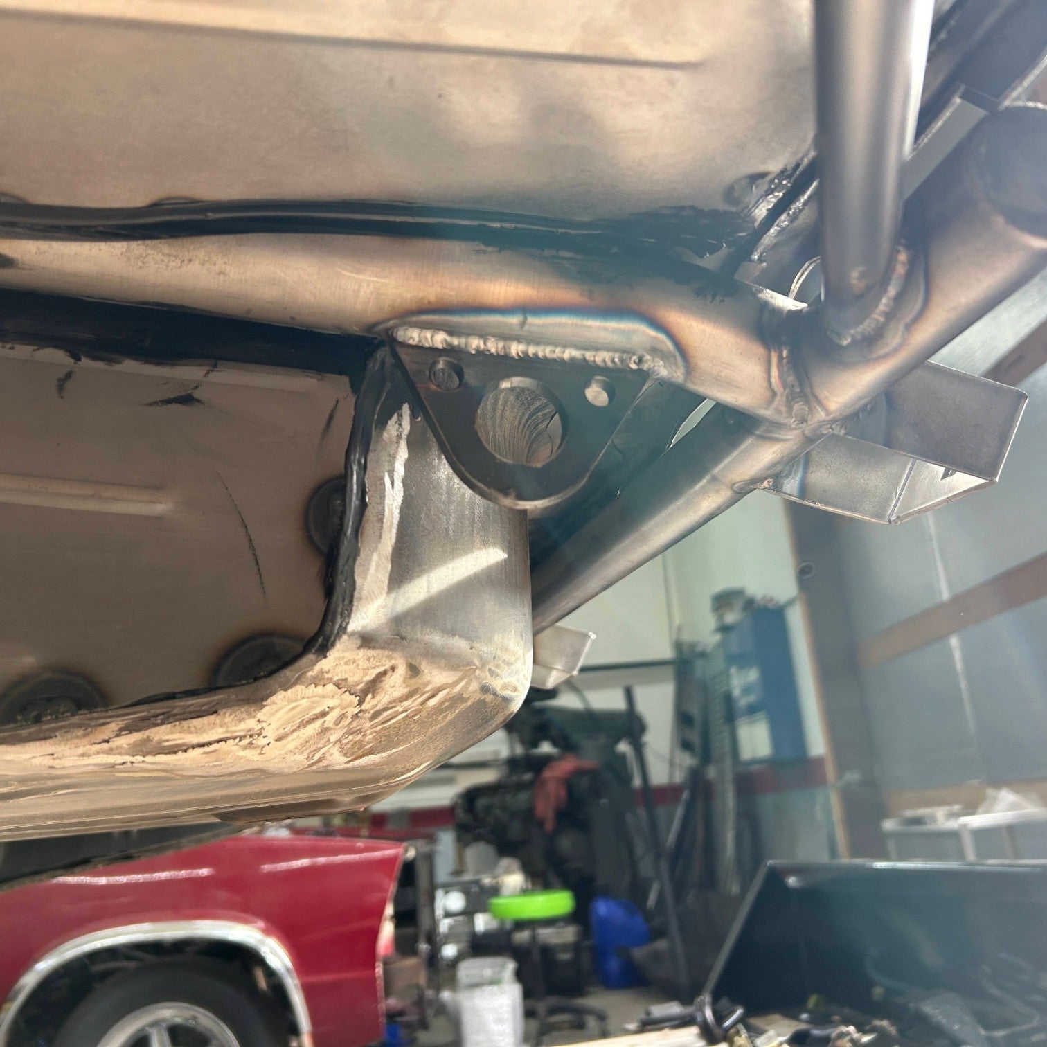 Henderson Race Shop Store weld-on steel tie-down tab welded to a race car chassis frame for secure transport