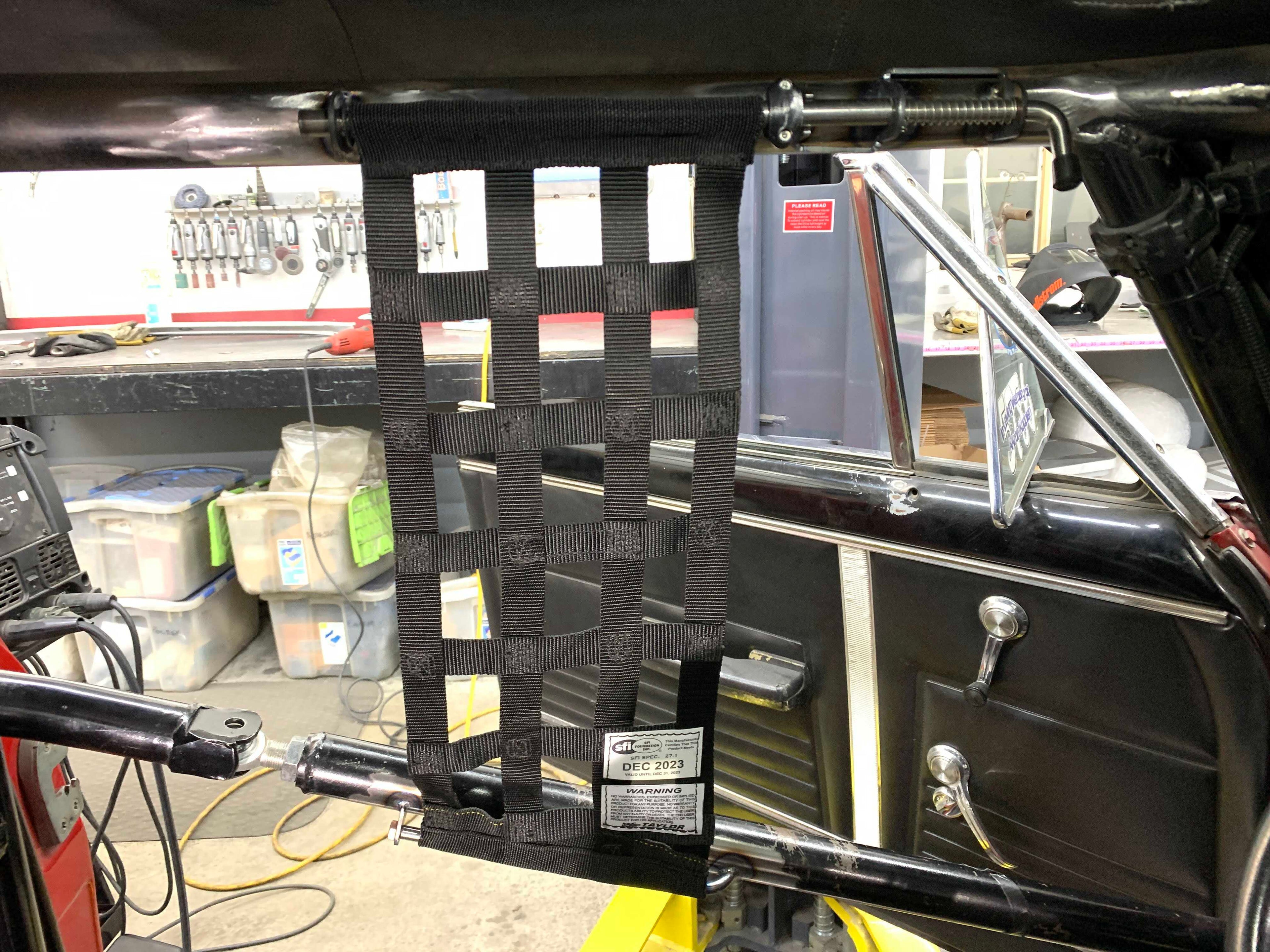 Henderson Race Shop Store window net mount kit with black mesh net installed on a racing roll cage